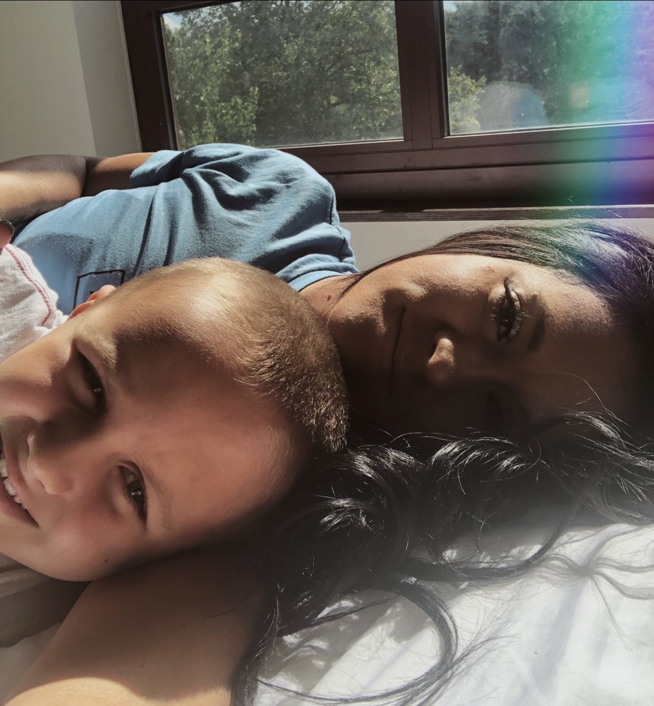 Kristen Durham resting cheek-to-cheek with her son Riley in soft window light